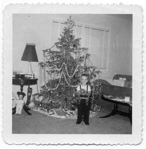 [Young Boy Holding a Toy in Front of a Christmas Tree]
