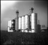 Photograph: [Grain Eleavtors in a Grain Field]