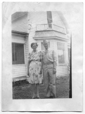 [Agnes and Melvin Hansen in Front of Family Home]