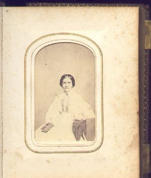 [Unidentified woman sitting in a chair with a book in her lap]