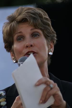 Primary view of object titled '[Close-up of Laura Miller holding white paper and microphone]'.