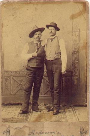 [Two unidentified men wearing vests and hats]