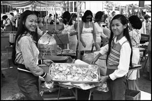 [Two Women display food from a Chinese Food Booth]