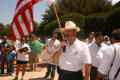 Thumbnail image of item number 1 in: '[Hector Flores standing in front of crowd with signs and American flag]'.