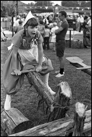 Primary view of object titled '[Dutch Girl Seesawing at the Texas Folklife Festival]'.