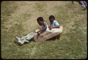 Primary view of object titled '[Visitors Sliding Down Berm at Institute of Texas Cultures]'.