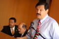 Photograph: [Domingo Garcia speaking at podium]
