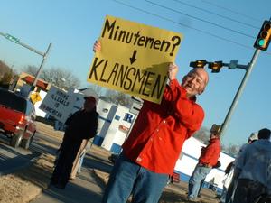 Primary view of object titled '[Man holding sign in front of other protesters]'.
