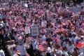 Photograph: [Protesters march with signs and American flags]