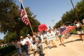 Primary view of [Young man with a U.S. flag on a tall pole leads protesters in their march]