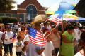 Photograph: [Protesters marching in front of City Hall with flags and umbrellas]