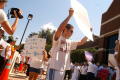 Thumbnail image of item number 1 in: '[Protesters walk in a circle with signs, one sign says, "Everyone is entitled to Life, Liberty, and the Pursuit of Happiness"]'.