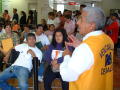 Primary view of [Employee from Ventanilla de Salud addresses the waiting room crowd]