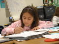 Primary view of [Girl works on completing her assignment]