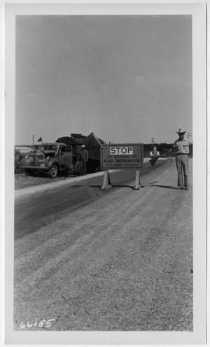 [Photograph of Construction Worker Next to Sign]