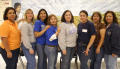 Thumbnail image of item number 1 in: '[Administrators pose in front of a mural at the Cesar Chavez School]'.
