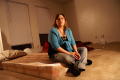 Photograph: [Woman sitting on floor on bare mattress]