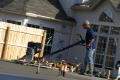 Primary view of [Man pushing equipment in front of house under construction]