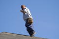 Primary view of [Man standing on roof and talking on cellular phone]
