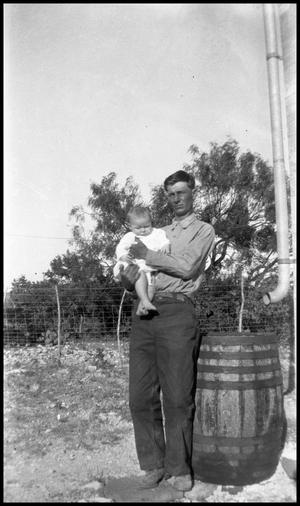 [Photograph of a Man Holding a Baby Outside]