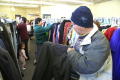 Primary view of [People of all ages look through racks of clothing]