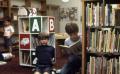 Primary view of [Three unidentified boys in Emily Fowler Public Library]