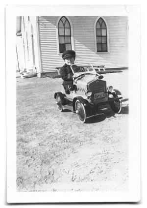[Young boy in toy car]