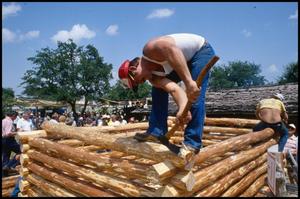[Man Working on Log House Construction]