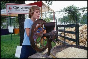 [Young Boy Shelling Corn with a Machine]