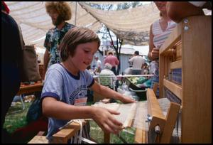 [A Young Boy Working on a Loom]