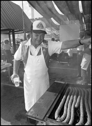 Primary view of object titled '[Man Cooking Sausage in Alsatian Food Booth]'.