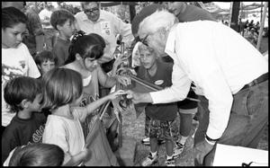 Primary view of object titled '[Jim Braud Shows Crawfish to Visitors]'.