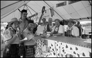 [Members of San Antonio Pipes and Drums at the Scottish Food Booth]