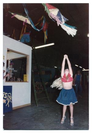 [Young Girl Looking Up at Piñatas]