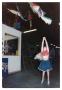Photograph: [Young Girl Looking Up at Piñatas]