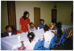 [Children at Table and Links Member During Christmas Party]
