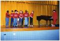 Photograph: [Choir Children on Stage with Piano Player]