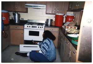 [Woman Seated on Floor in Kitchen]