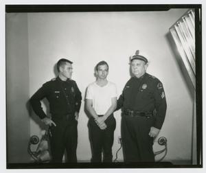 Primary view of object titled '[Lee Harvey Oswald Standing With Officers]'.