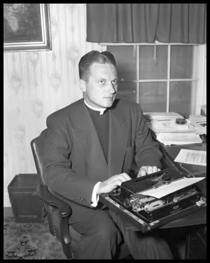 [Photograph of a Priest in an Office]