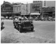 Photograph: Two men in jeep on Congrees ave. near Queen Theatre