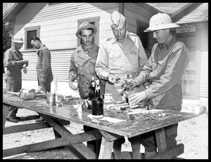 Soldiers making explosives with nails and cans