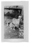 Photograph: Marie Burkhalter on a pile of rocks under a railroad bridge