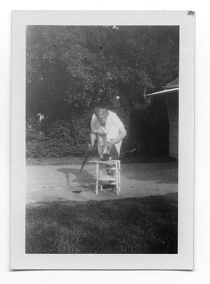 Primary view of object titled '[Carolyn Scott sawing a piece of wood]'.