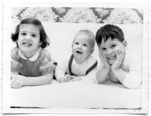 Three children smiling at the camera