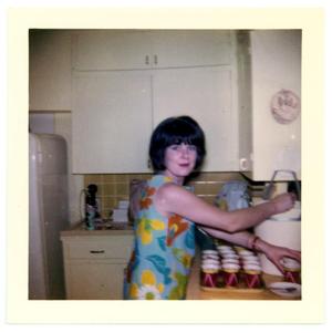 Woman in a kitchen filling filling cups