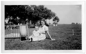 Woman sitting in the grass with a baby