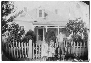 Theo Scrivner and two children outside a house