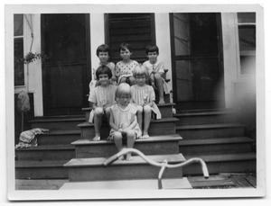 The Delaney and Vise children sitting on the steps of a house