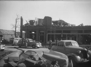 [Photograph of Vehicles, People, and Damaged Building After Tornado]